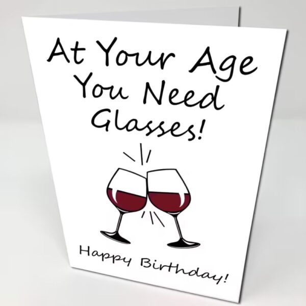 White Birthday Card with a photo of wine glasses and text "At your age you need glasses, happy birthday"