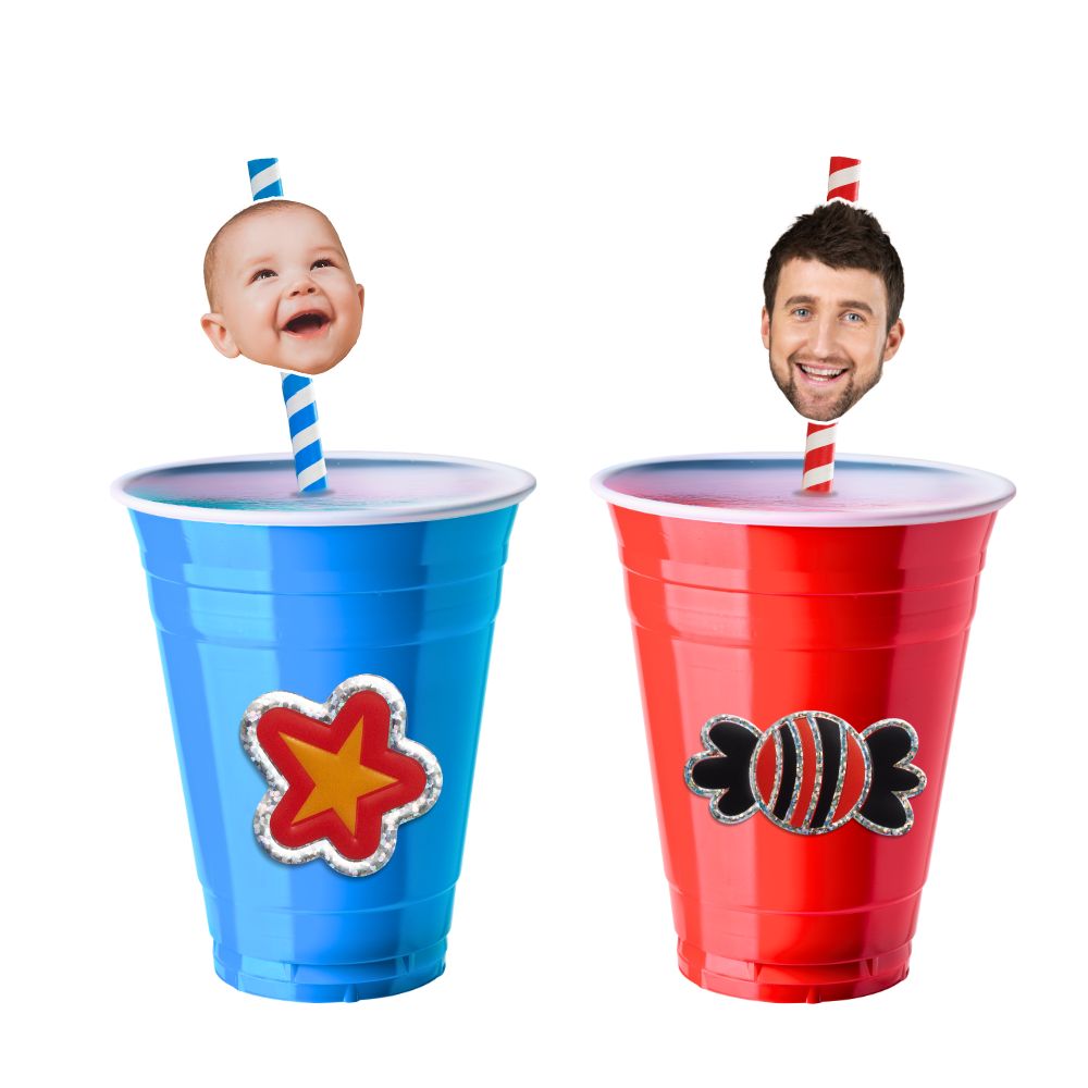 Two party cups with personalised face straws, one with a baby face on a blue and white straw and another with a man's face on a red and white straw.