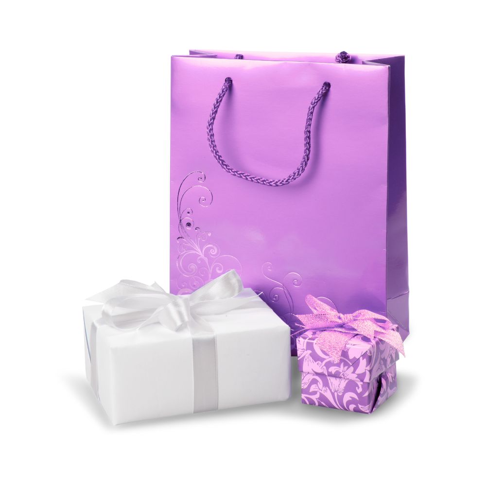 A purple gift bag with a floral design, containing two wrapped presents, one in white paper and the other in purple patterned paper.