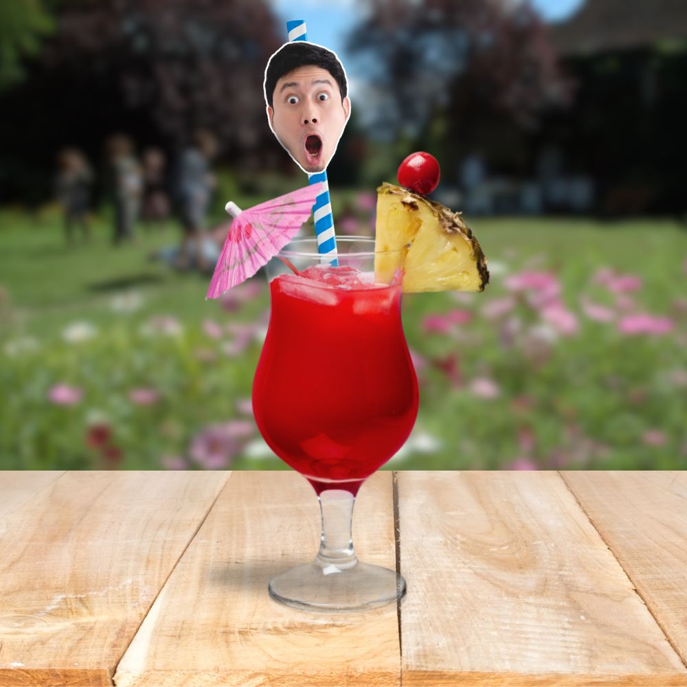 A red tropical drink with pineapple and cherry garnish, featuring a personalised face straw with a surprised face on a blue and white straw.