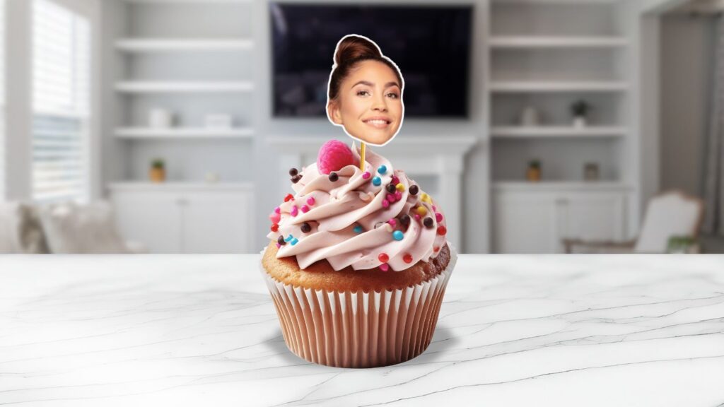 A fun and creative birthday party cupcake with a personalised face topper, set in a modern kitchen.